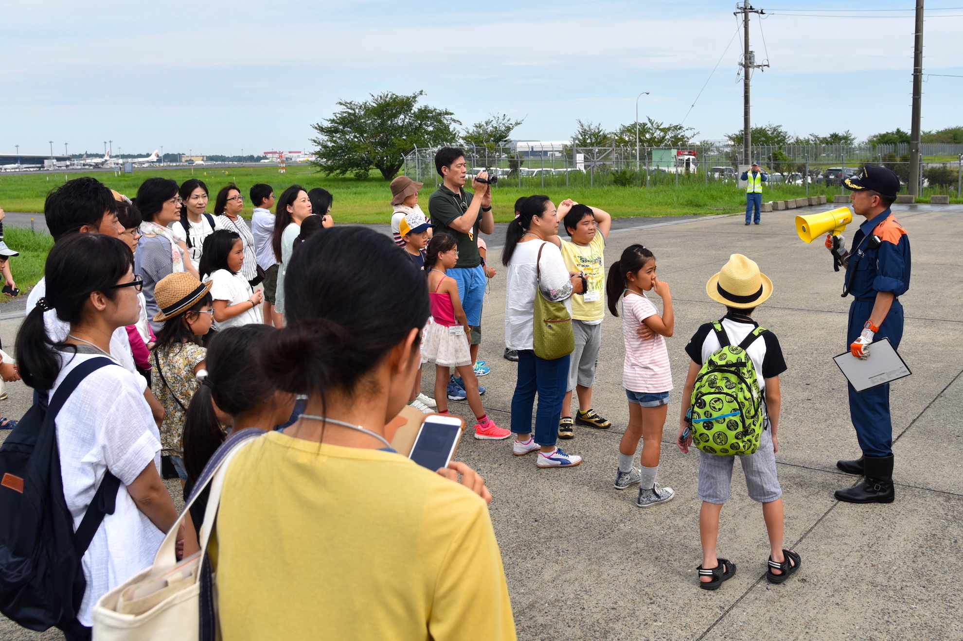 空港消防についての説明を真剣に聞く参加者たち