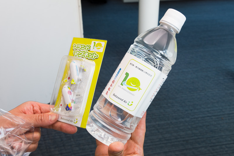 SNA74便（鹿児島10時55分発～羽田12時35分着）の搭乗客に記念品として、いずれも就航10周年ロゴマーク入りの関平鉱泉水、ソラシドマグネットをプレゼント