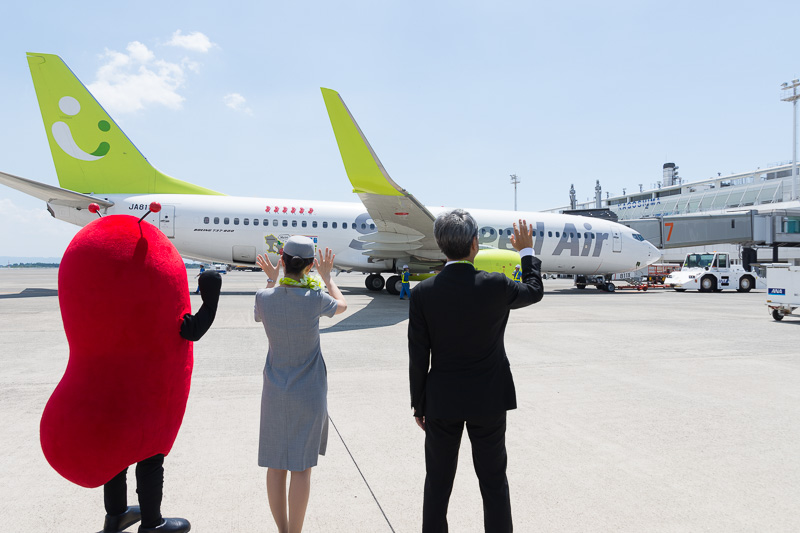 搭乗が始まるとボーディングブリッジを渡る乗客に手を振って出迎え