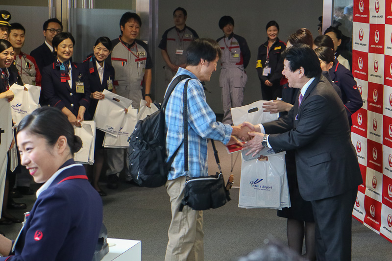 乗客に記念品を手渡す