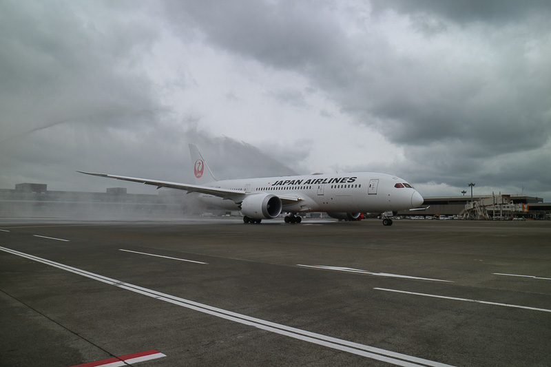 ボーイング 787-8型機はゆっくりと発進。あいにくの曇天と強風ではあったが、両脇の消防車が描くアーチをくぐっていく