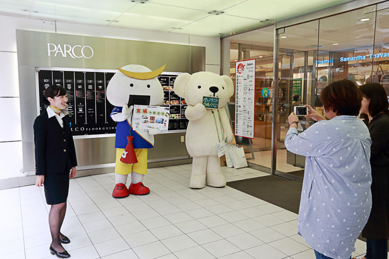 袋をプレゼントされた人たちは「むすび丸」「ベア・ドゥ」をスマートフォンで撮影するなどして楽しんでいた