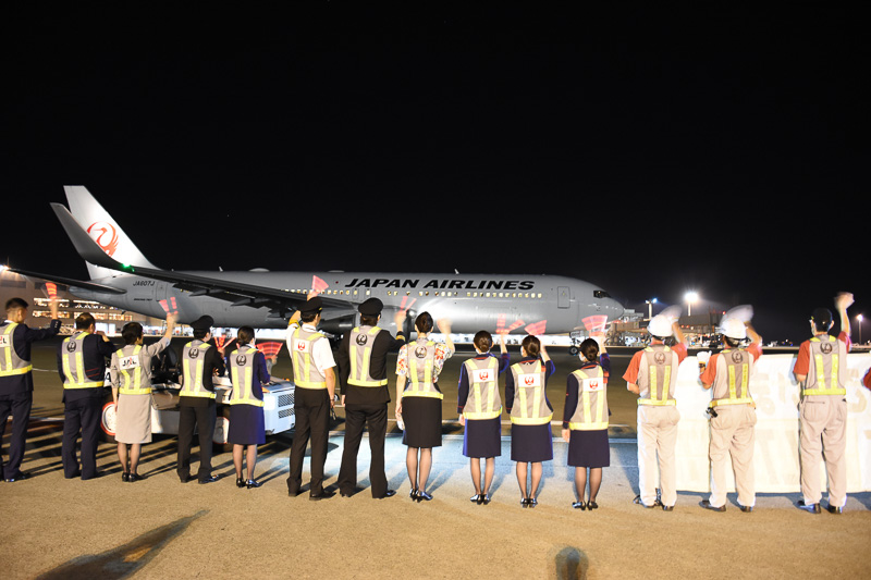 機内の乗客からよく見えるように、ペンライトを使って見送りを行なった