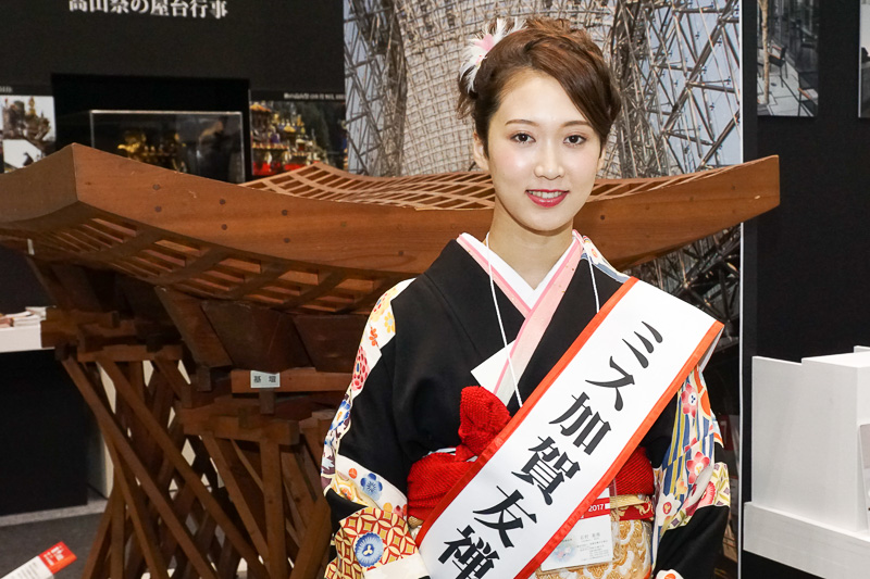 13代ミス加賀友禅の石村美侑さん。金沢駅正面に建築された「鼓門」の模型前で