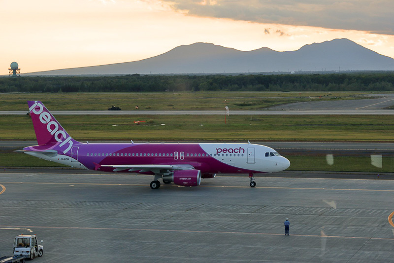 樽前山、風不死岳を背景に、新千歳空港を出発するMM725便（JA819P）