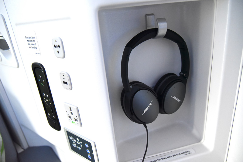 操作パネルには、モニター用のリモコンやリクライニングのボタン、ユニバーサルAC電源やUSBポートなどを集約。ボーズ製のノイズキャンセリングヘッドフォンを収納するスペースもある