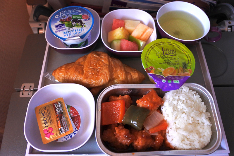「豚肉の炒め物 甘酢ソース タイライス」、クロワッサンにバター＆ジャム。そしてフルーツジュース