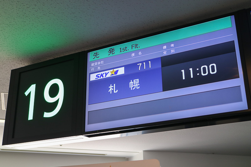 羽田空港 第1ターミナル19番ゲートにおいて、新千歳（札幌）行きSKY711便の搭乗客にスカイマーク株式会社 代表取締役社長の市江正彦氏や、同社スタッフが搭乗客にプレゼントを手渡した