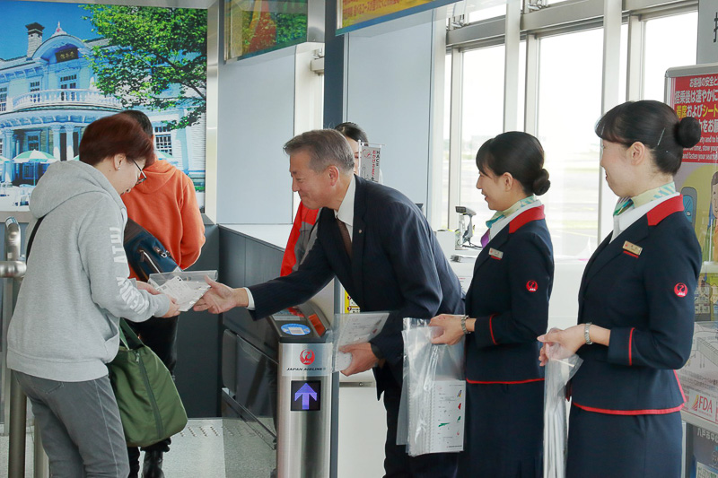 乗客に記念品を手渡していく