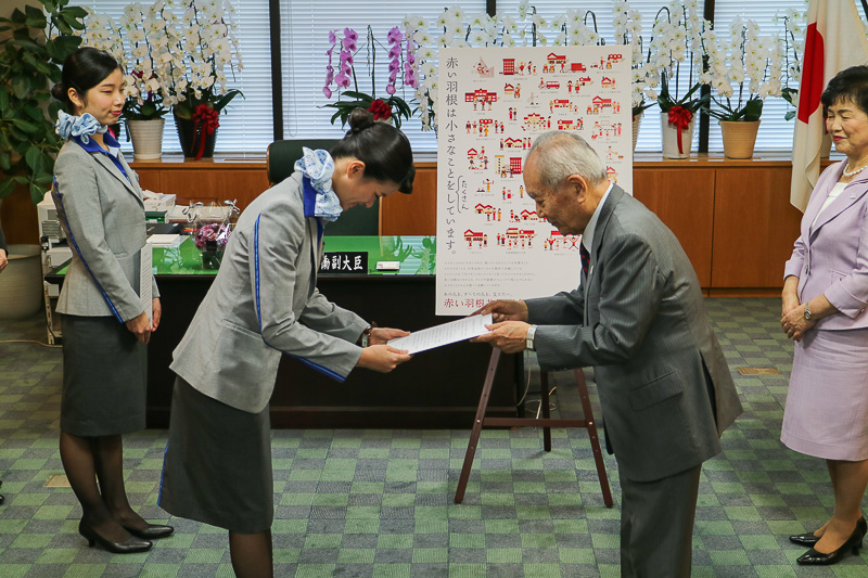 社会福祉法人 中央共同募金会 会長 斎藤十朗氏からANA CAの上山聡子氏へメッセージが手渡された