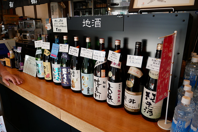 地酒コーナーでは、ワンショット100円で好きな地酒を味わえる
