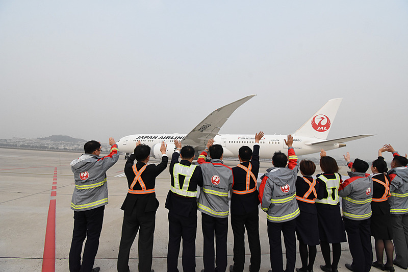 スタッフが中国語の横断幕（記事冒頭の写真参照）でJL828便を見送った