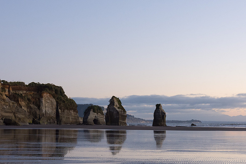 スリー・シスターズ・アンド・エレファント……だった岩たち。写真中央に立つ2つの岩が姉妹。その右の水面に少しだけ顔を見せている小さな岩が姉妹の3人目。そして、左側にある中央がくり抜かれた岩が象の形をしていた岩で、頭部が崩れて足だけが残っている
