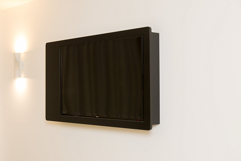 42インチテレビはワークデスクの上部の壁に設置されている