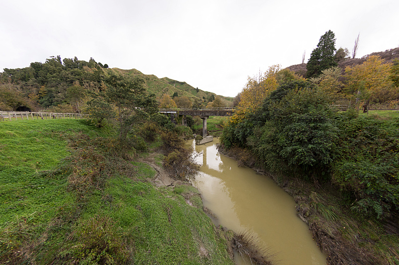 街の脇を流れるファンガモモナ川と、その川をまたぐフォーゴットン・ワールド・ハイウェイの橋