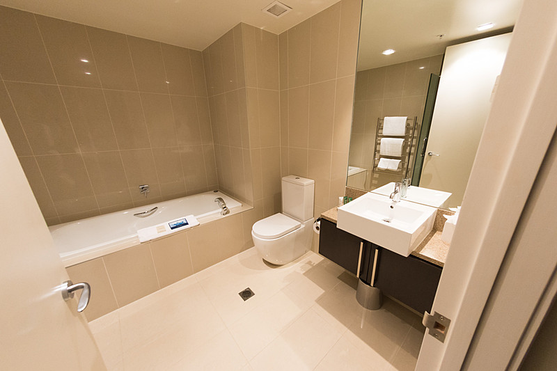 バスタブとシャワーブースを備える広いバスルーム。タオルウォーマーが便利