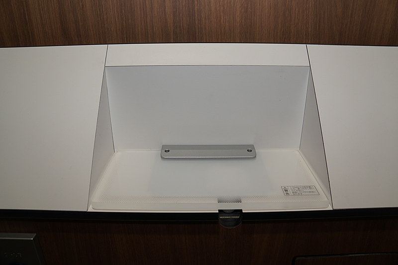 女子トイレの個室。通常は段差がある壁面を斜めにして小物などを置けないように忘れ物対策を行なった個室トイレ。スマートフォンやお財布など小物を置けるスペースを別途用意。物を置くとライトアップして、忘れ物をしないよう促す