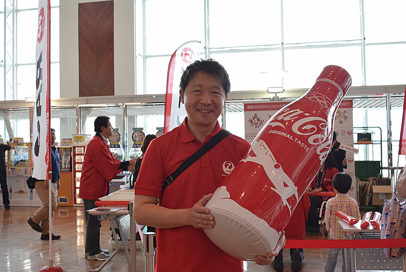 日本航空株式会社 東京2020オリンピック・パラリンピック推進部長 小西一史氏。限定デザイン缶のビッグダミーを抱えてアピール