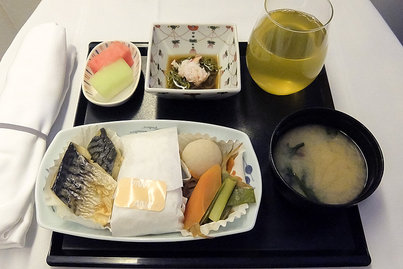 成田到着前に提供された和食メニュー。さっぱりとしたサバの塩焼きに、野菜の煮物とご飯がよく合う。めかぶ酢もよいアクセントに