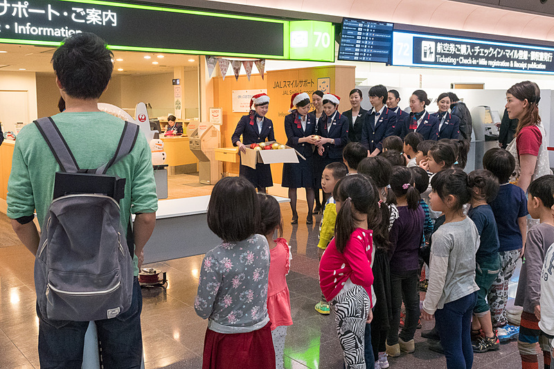 アンジュ保育園の園児23名が到着。JALスタッフからクリスマスツリーに飾り付けるオーナメントを受け取る
