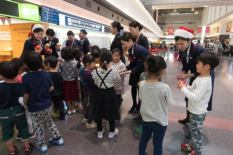 アンジュ保育園の園児23名が到着。JALスタッフからクリスマスツリーに飾り付けるオーナメントを受け取る