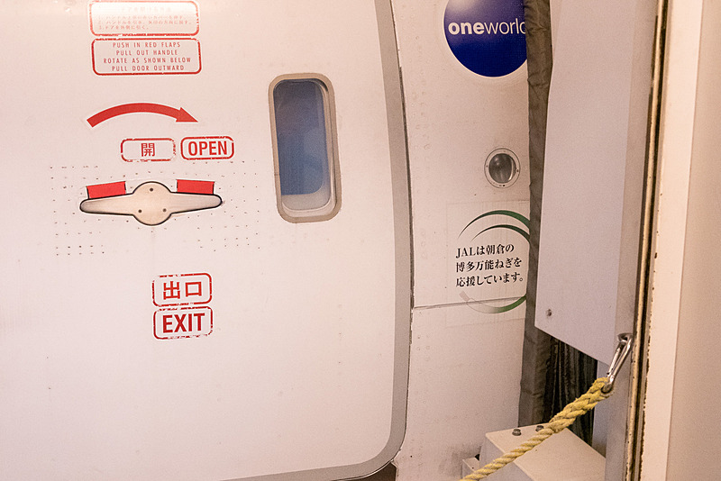 L1ドア脇の下方に「JALは朝倉の博多万能ねぎを応援しています。」と博多万能ねぎをデザインしたデカールが貼られている