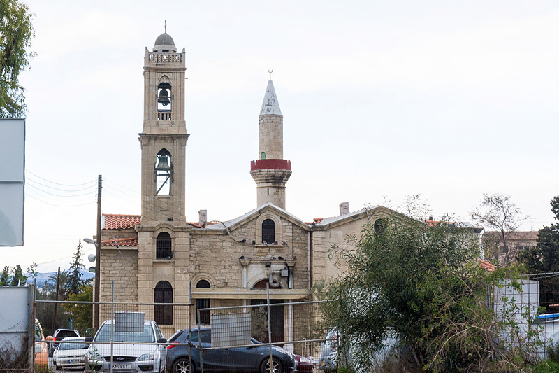 道路をはさんで並ぶ聖アントニオス教会（Saint Antonios Church）とコプルル・モスク（Koprulu Mosque）