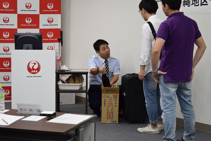 機内に預けられるお酒は5Lまで。箱の中には1升瓶が3本入っている。1本は持ち込めないことを説明する