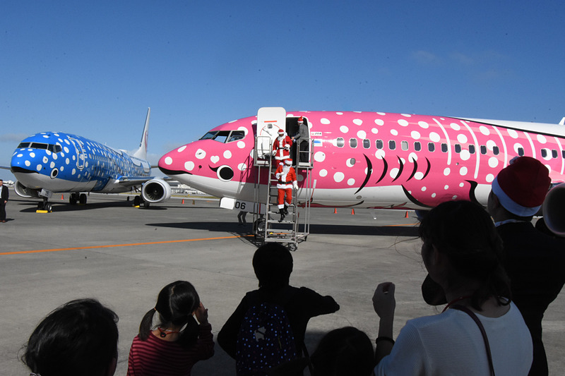 機体からサンタが降りてきて子供たちと記念撮影