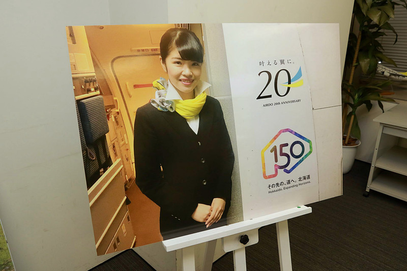 CA（客室乗務員）の立つ機体搭乗口の横に貼ってある就航20周年ロゴマーク（上）と北海道命名150年ロゴマーク（下）の掲出は、2018年12月まで実施予定だ