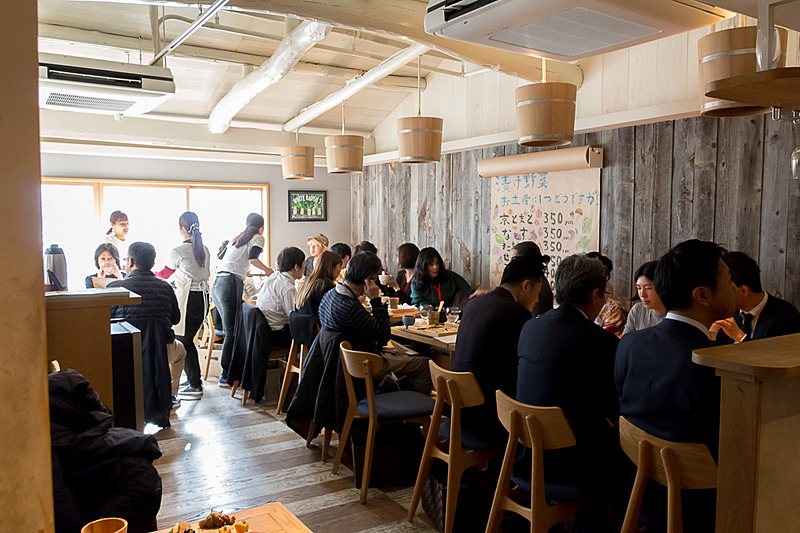 1階はキッチンとカウンター、テーブル席が用意されており、木材を多く使用した内装が落ち着く空間を演出している。2階にはテーブル席が用意されている