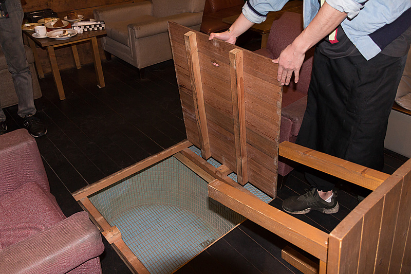 大浴場を取り壊さず、その上に板を敷いただけの内装なので、天井には換気窓、床下には浴槽といったものが残されている