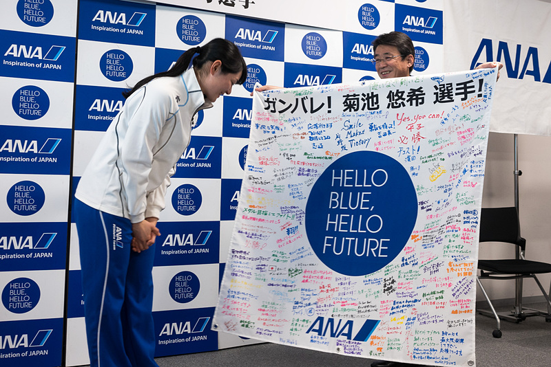ANAホールディングス株式会社 代表取締役社長の片野坂真哉氏が、菊池悠希選手へグループ社員の応援メッセージが書かれた横断幕と花束を贈った