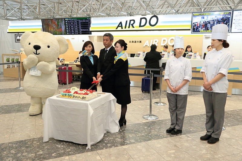 千歳市のお菓子屋「もりもと」がAIR DOカウンターリニューアル記念に作ったケーキを前に記念撮影が行なわれた