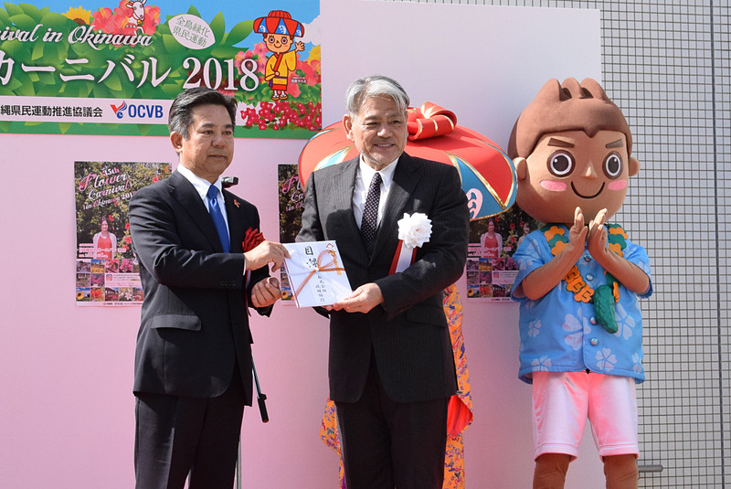 各登壇者から平良朝敬会長へプランターの目録が渡され、平良会長がまとめて久茂地都市開発へ贈呈した