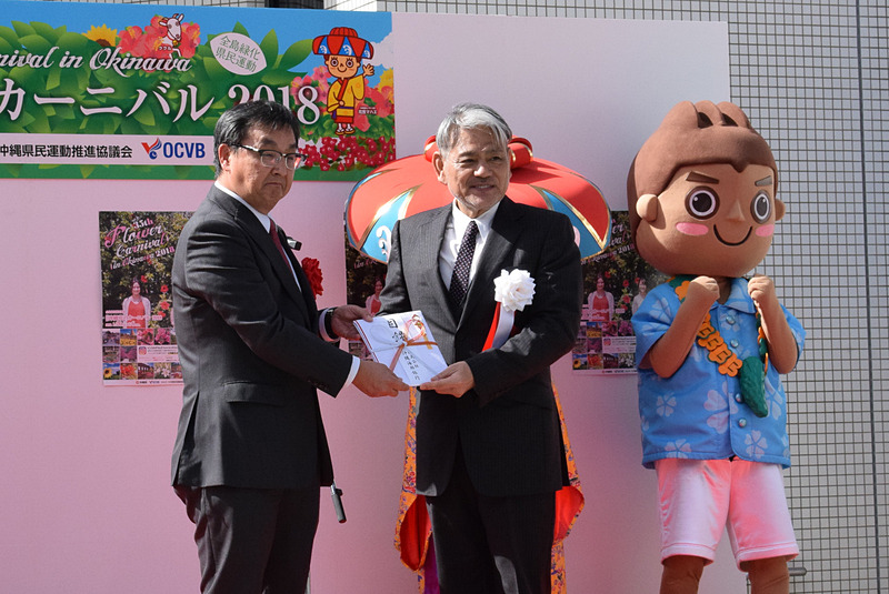 各登壇者から平良朝敬会長へプランターの目録が渡され、平良会長がまとめて久茂地都市開発へ贈呈した