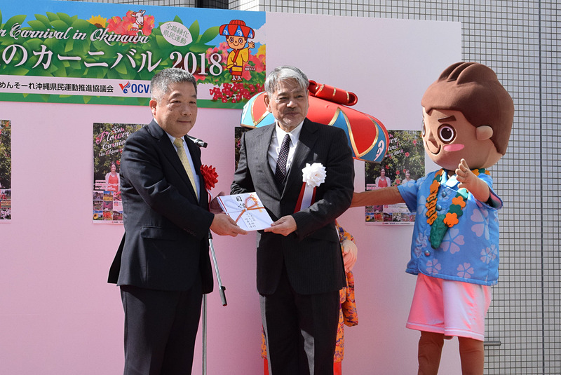 各登壇者から平良朝敬会長へプランターの目録が渡され、平良会長がまとめて久茂地都市開発へ贈呈した