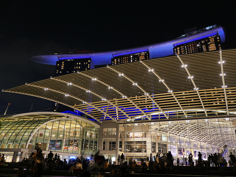 夜のマリーナ・ベイ・サンズをイベント広場から見上げるの図