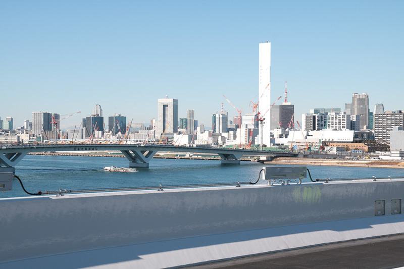並行する環状2号線の豊洲大橋。橋を渡った先に見えるクレーンの数々は、2020年オリンピック・パラリンピックの選手村の建設機材