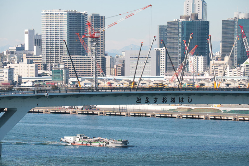 並行する環状2号線の豊洲大橋。橋を渡った先に見えるクレーンの数々は、2020年オリンピック・パラリンピックの選手村の建設機材