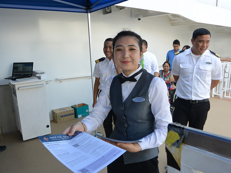 乗船口で船員から船内新聞を手渡され