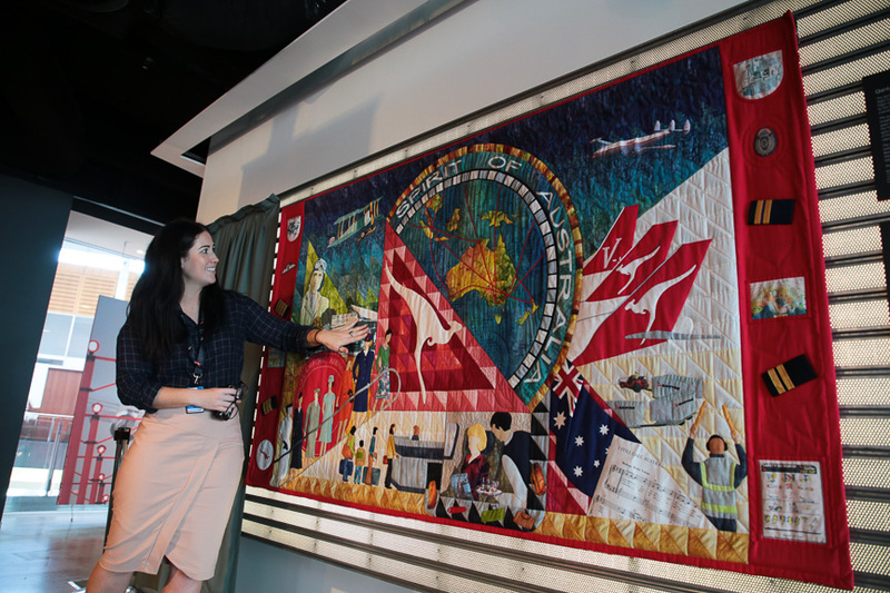 カンタスの元CA（客室乗務員）の方の手作りタペストリー。説明しているのはカンタス航空の広報担当者