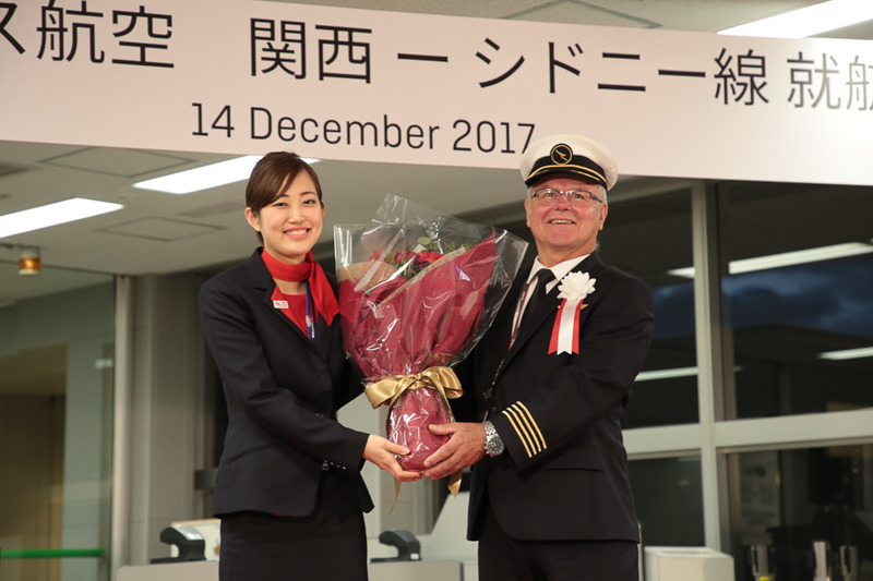 QF34便の就航初便の機長を務めるビル・ラング氏には花束が贈られた