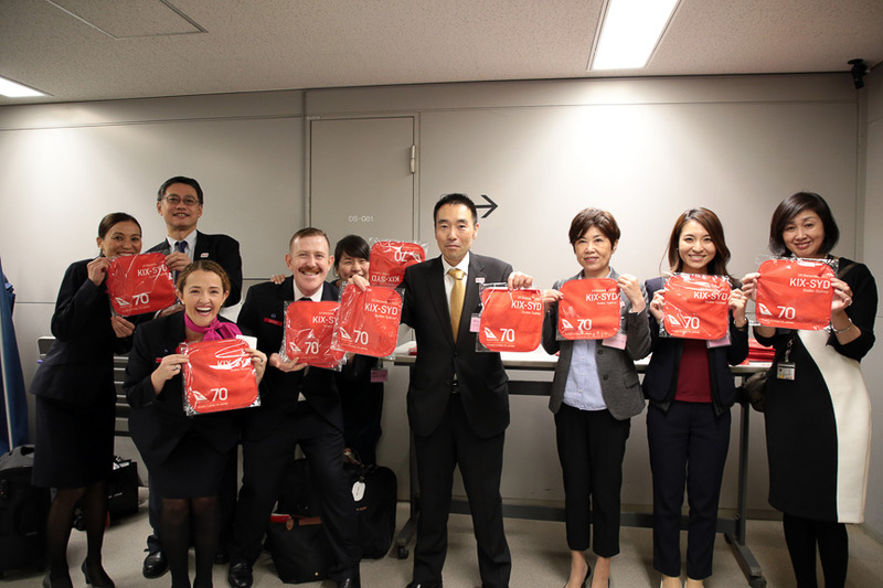 カンタス航空のコーポレートカラーのハンドタオル。右上に関空～シドニー線就航、左下に日本路線70周年の文字が入っている