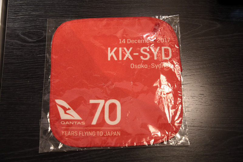 カンタス航空のコーポレートカラーのハンドタオル。右上に関空～シドニー線就航、左下に日本路線70周年の文字が入っている