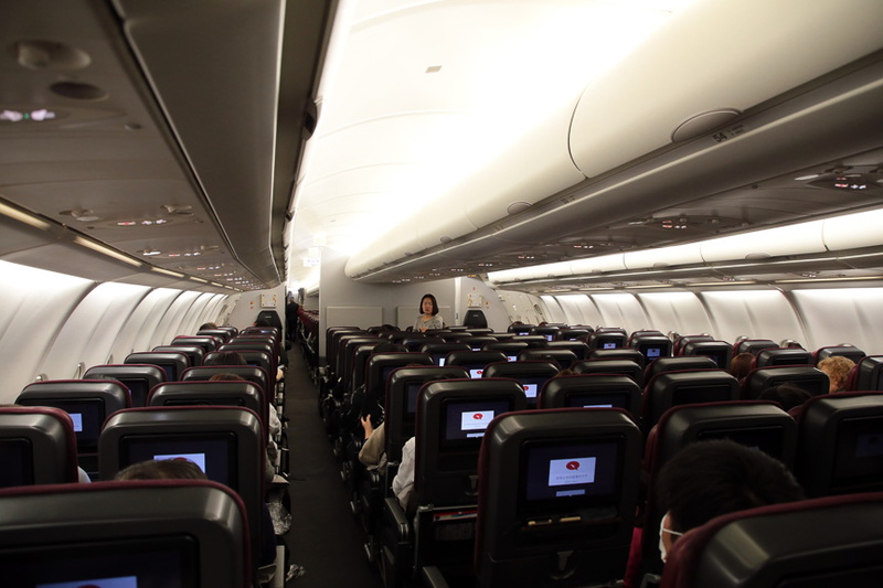 機内後部から見たエコノミークラス。シートバックは黒で、座面は赤。配置は横に2-4-2（機体後方は一部2-3-2）で計269席