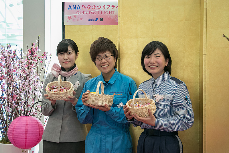 ANAグループ各部門の女性スタッフが、乗客にお菓子を配る