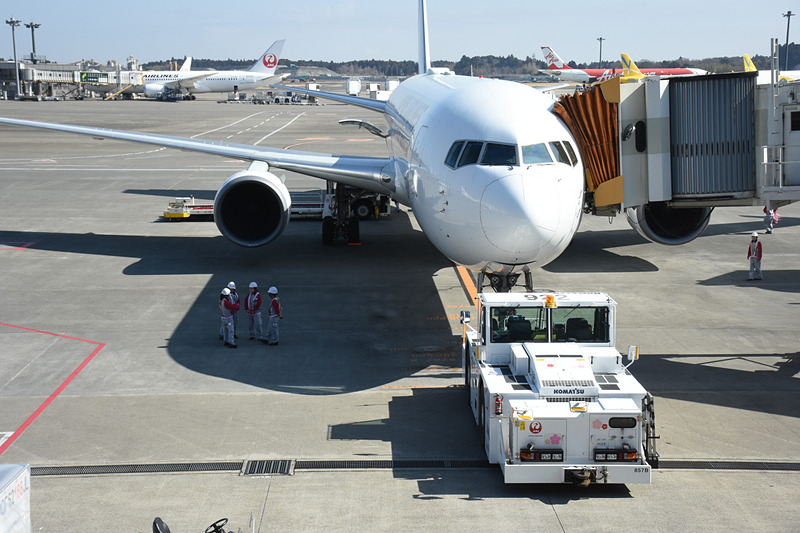 スポットで搭乗を待つJL941便（ボーイング 767-300ER型機）。トーイングカーやトーイングトラクターにもひなまつり飾りを施してある