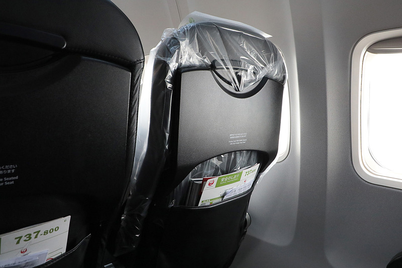 窓側の座席が愛犬用。クレートごとシートベルトで固定する。シートはまるごとビニールで覆われている