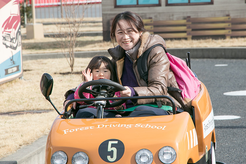 市街地コースをドライブしながら交通ルールを学ぶ「森の教習所」。「止まれ」の標識では一時停止して安全を確認